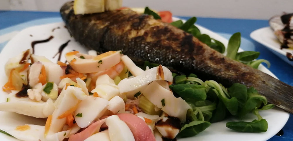 piatti di pesce durante l'aperitivo in spiaggia